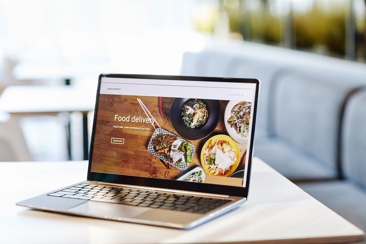A laptop showing a food website sits on a table.