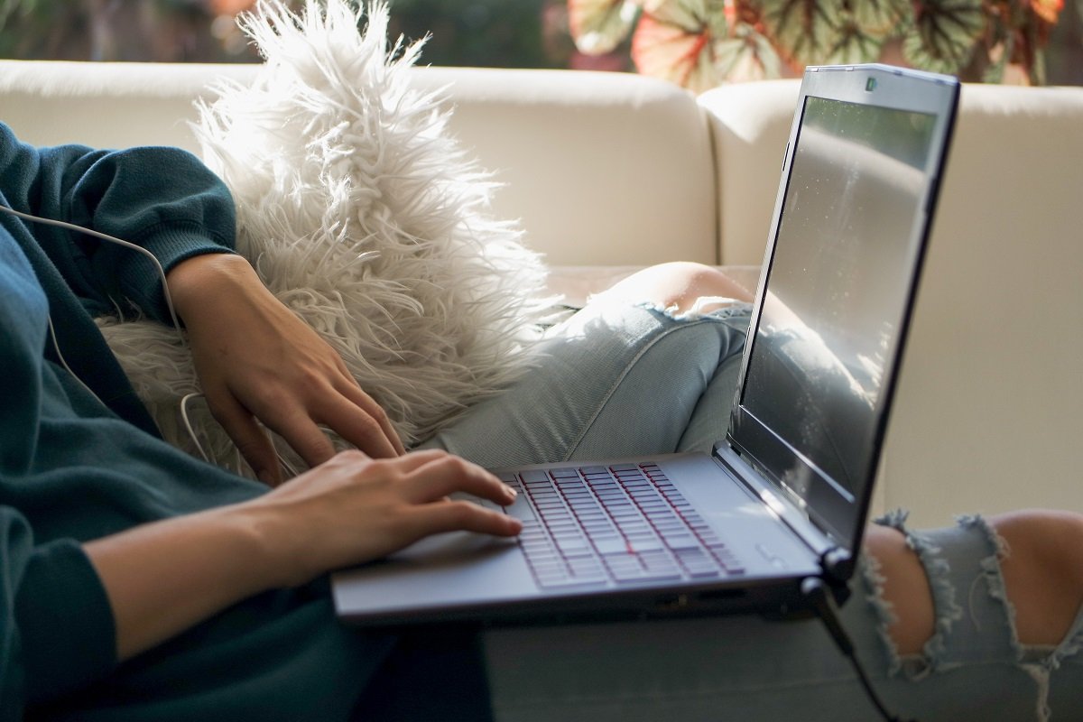 A person using a laptop on a couch