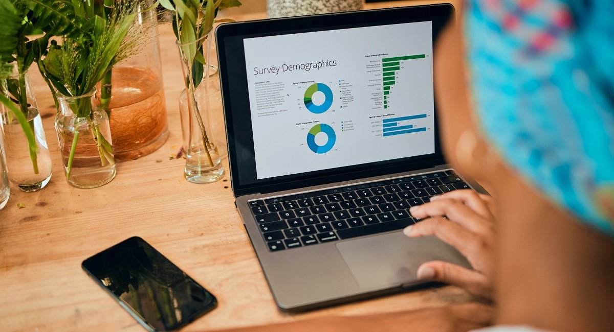 A digital marketer looking at data analysis on a laptop